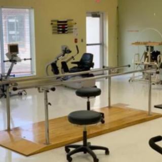 A well-equipped physical therapy and rehabilitation room with various exercise equipment.