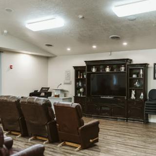 A cozy living room setup featuring recliner chairs and a large television.