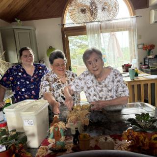 A warm moment in the kitchen as three women engage in a creative culinary activity.