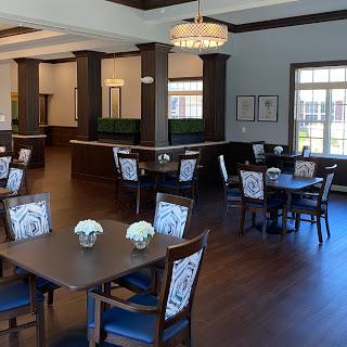 A spacious and elegantly designed dining area featuring modern furniture and bright natural light.