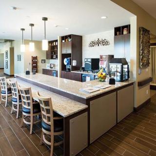 A modern kitchen with a large island, bar stools, and stylish pendant lighting.
