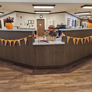 A cozy reception area decorated for autumn with pumpkins and bunting.