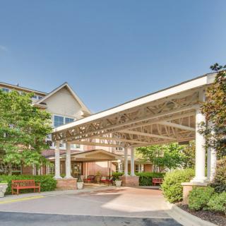 A welcoming building entrance with a spacious canopy and landscaped gardens.