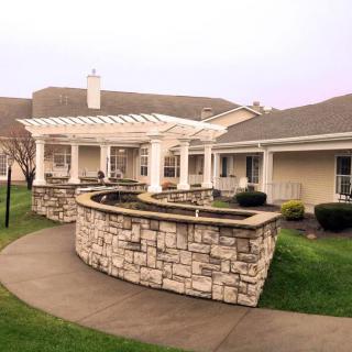 A view of a building with stone walls and a surrounding pathway.