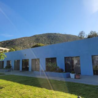 A blue building set against a mountain under a clear sky.