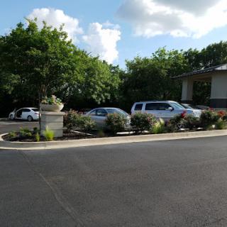 A view of a parking area surrounded by greenery and blue skies.
