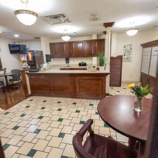 A cozy kitchen and dining area with wood cabinets and a tile floor.