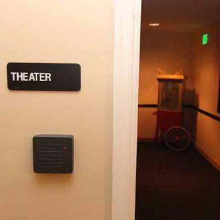 Entrance to a theater with a popcorn machine visible in the hallway.