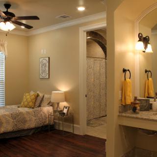 A cozy and modern bedroom featuring a comfortable bed, soft lighting, and a stylish bathroom area.