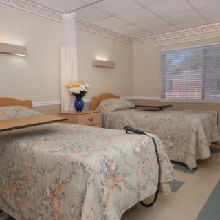 A hospital room with two beds and medical facilities.