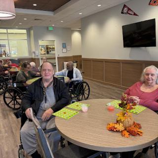 Residents enjoying a meal together in a cozy dining area decorated for autumn.