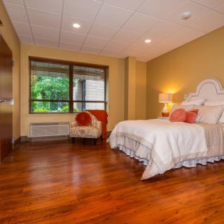 A cozy bedroom with warm wooden flooring and elegant decor.