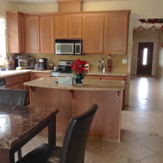 A modern kitchen with wooden cabinets, a central island, and adjacent dining area.