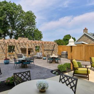 A beautifully landscaped outdoor patio area with seating and greenery.