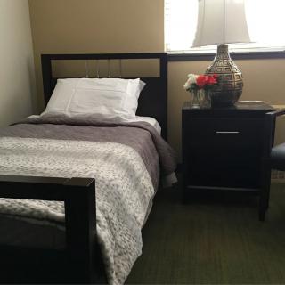 A cozy bedroom with a single bed and nightstand.