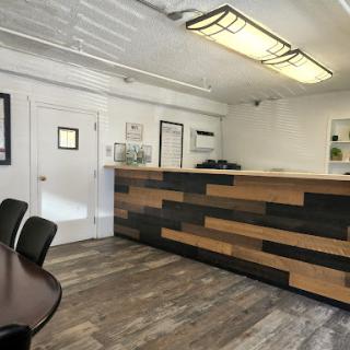 A modern reception area featuring a wooden front desk and contemporary furnishings.