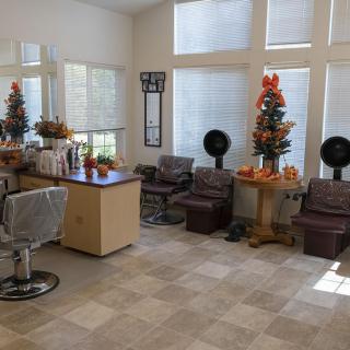 A well-lit salon interior with chairs, mirrors, and festive decorations.