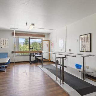 A physical therapy room equipped with parallel bars for rehabilitation exercises.
