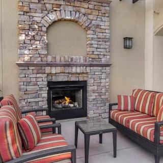 An inviting outdoor patio with comfortable seating and a cozy stone fireplace.