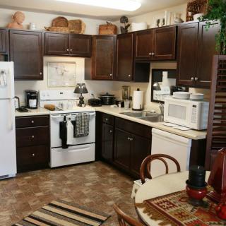 A cozy traditional kitchen with dark cabinets and standard appliances.