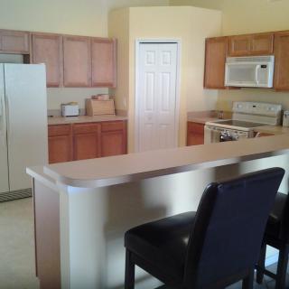 A modern kitchen with a countertop and bar stools.