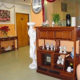A cozy interior space featuring elegant wooden furniture, decorative items, and a statue.