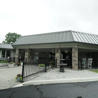 A welcoming entrance of a modern facility with a stone facade and a well-maintained landscape.
