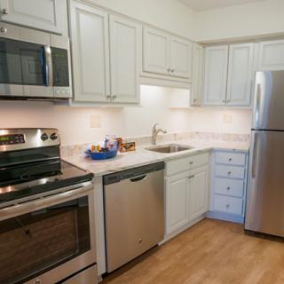 A modern kitchen with stainless steel appliances and white cabinets.