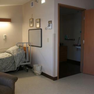A hospital room with a bed, featuring simple and functional decor.
