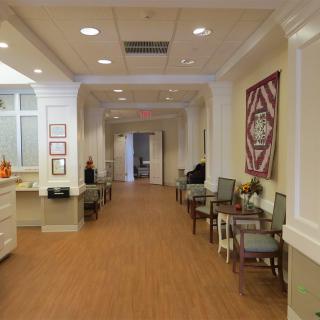 A bright and welcoming hallway with seating areas and decorative elements.
