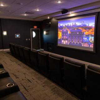 A cozy home theater with comfortable seating and a large projector screen.