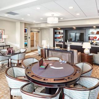 A luxurious lounge with a poker table and comfortable seating.