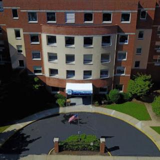 An aerial view of a modern residential building with landscaped surroundings.