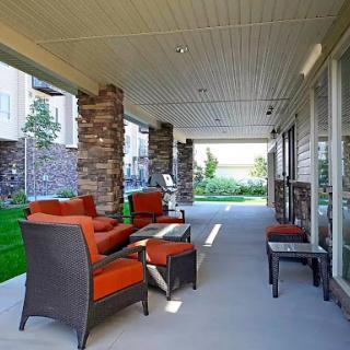 A cozy outdoor patio area featuring stylish seating and a landscaped view.
