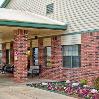 A hotel entrance with brick walls and a flowerbed.