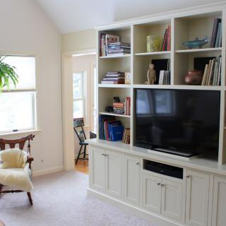 A cozy living room with a large bookshelf and television.