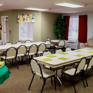 An empty classroom or meeting room set up with tables and chairs, ready for an event or class.