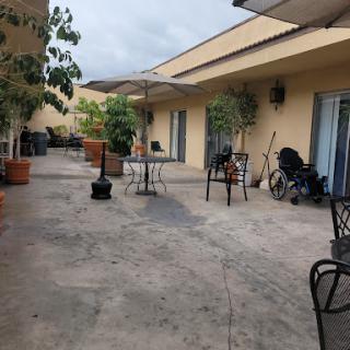 A serene outdoor courtyard featuring plants, tables, and chairs, perfect for relaxation.