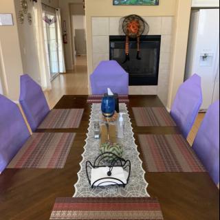 A well-decorated dining room featuring a table set with placemats and a decorative runner.