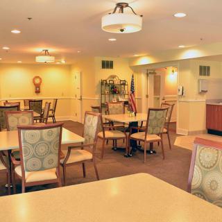 A well-lit dining area with multiple tables and chairs, creating a welcoming community space.
