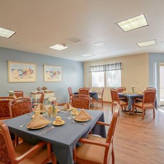 A modern dining room with neatly arranged tables and chairs, featuring elegant place settings.