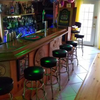 A cozy bar interior with a row of stools lined up along the counter.