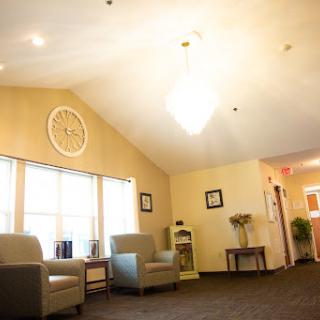 A cozy waiting area featuring comfortable chairs, a wall clock, and ample natural light.