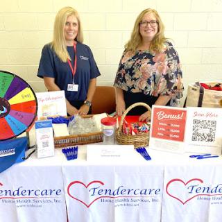 Representatives from Tendercare at a community event, showcasing their services and engaging with attendees.