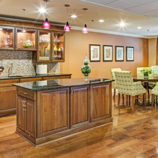 A modern kitchen and dining area featuring wooden cabinetry, an island counter, and elegant interior design.