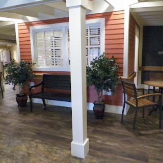 A cozy waiting area featuring a bench, a small table, and potted plants.