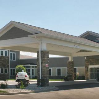A modern building entrance with a covered walkway and stone accents.