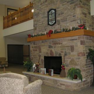 A cozy indoor living area featuring a stone fireplace with decorative items on the mantle and comfortable seating.