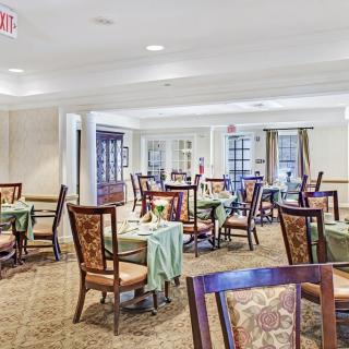 A spacious dining room with elegantly set tables and chairs.