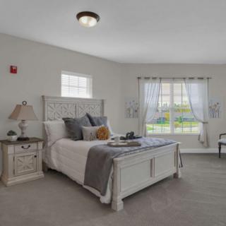 A cozy, well-decorated bedroom with a large bed and ample natural light.